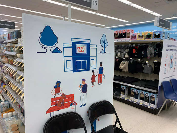 The pharmacy is located in the back of the store, with chairs and waiting areas for people to get vaccinated.