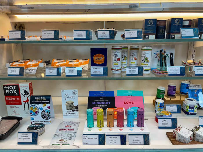 In the center of the story is a colorful display case with everything from THC-infused drinks to chocolate edibles.