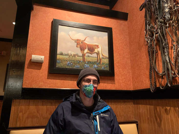 With my fiance Joe for scale, this is how the harnesses, wood paneling, and cow paintings all came together to create the vibe.