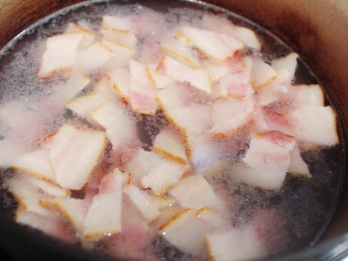 Rather than frying the bacon right away, the recipe requires placing it in simmering water for 10 minutes.