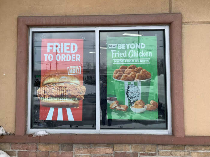 Signs on windows around the restaurant advertised chicken sandwich and new Beyond Fried Chicken nuggets.