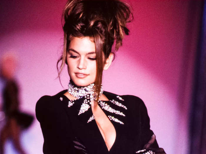 In 1990, Cindy Crawford walked the Paris Fashion Week runway in a glittering Thierry Mugler bodysuit with a plunging neckline and fishnet tights.