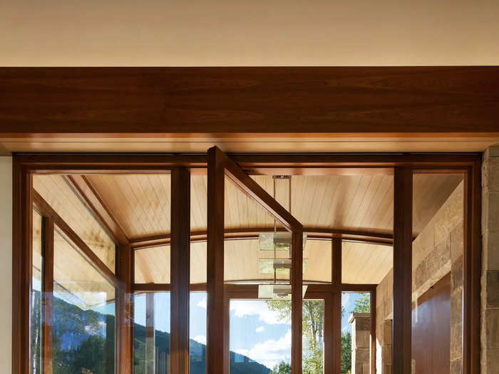 Upon entry through a glass pivot door, visitors step inside the home