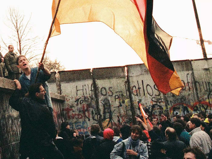 The Berlin Wall split East and West Berlin into occupation zones until borders were opened on November 9, 1989, and the wall was torn down by East German border guards and residents.