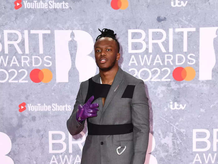 YouTuber KSI walked the red carpet in a gray suit and a black harness that was intertwined with his jacket.