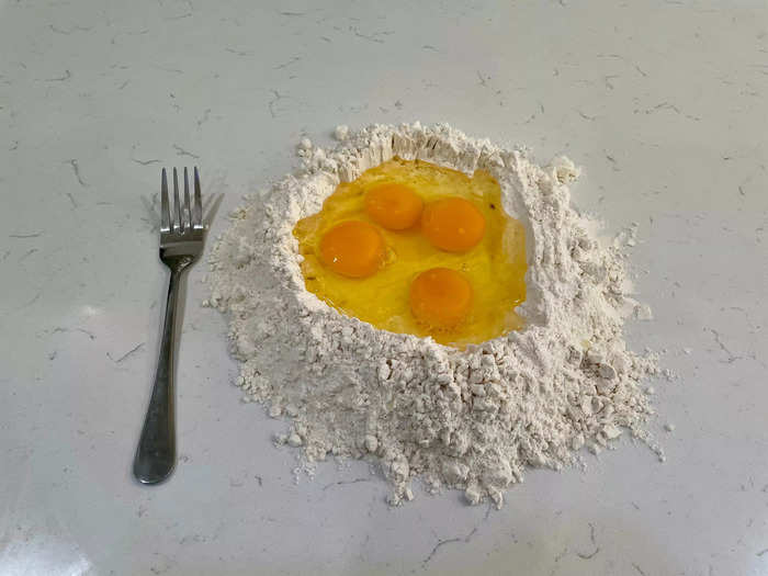 Crack the eggs into the well without spilling.