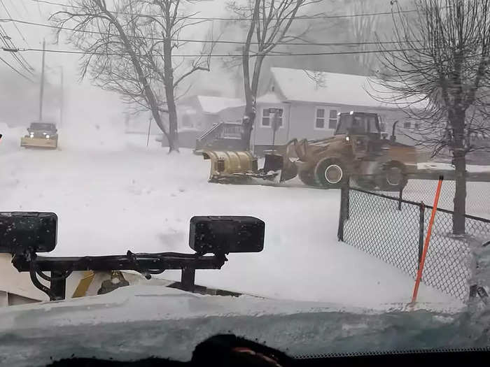 At one intersection, Gaffin drives his dump truck past a passenger pickup and a front-end loader, each equipped with plows.