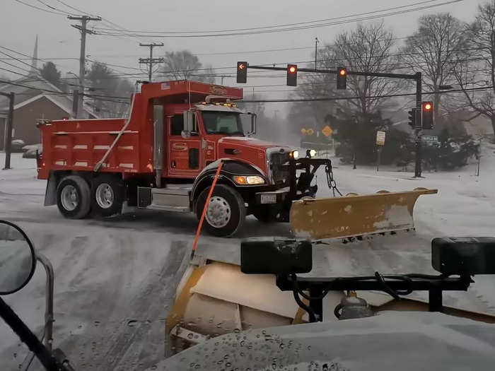 Company trucks criss-cross the town as the storm picks up.