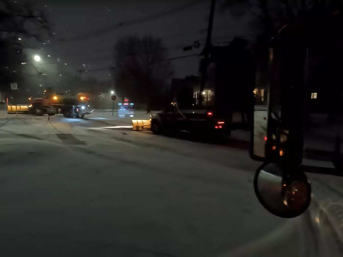 The crews head out to the streets before dawn. Snow is falling, but accumulation is still less than an inch.