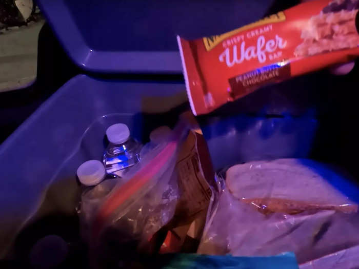 In a large cooler on the passenger seat, he has a stash of water, granola bars, peanut butter sandwiches, a steak sub, and first aid medication.