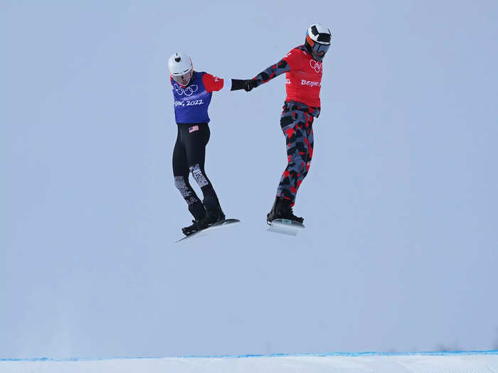 Snowboarders levitate in the snowboard cross.