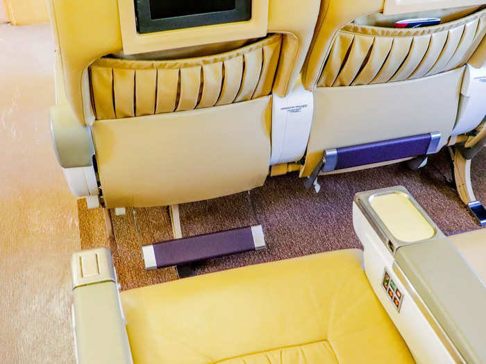 Amenities at each seat include a personal entertainment system, footrest, and foldable tray tables.