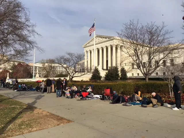 A line of people waiting outside the US Supreme Court, some with tents