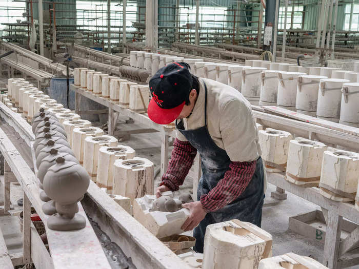 Workers fill molds of the mascots