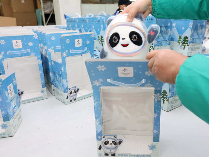The pandas are placed into blue boxes decorated with snowflakes and a picture of Bing Dwen Dwen; the boxes also have handles on top for easy carrying.