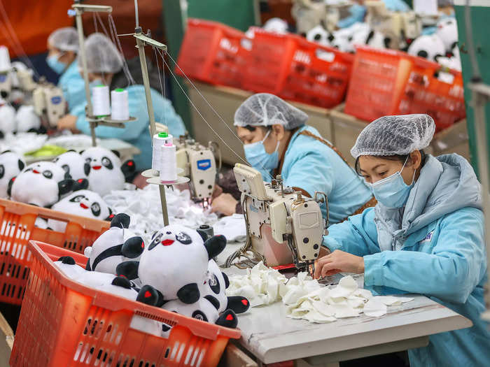 Workers sew the pieces together to form the stuffed animals