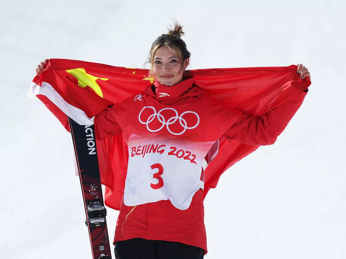 2/15: Silver medalist Eileen Gu holds the Chinese flag behind her back while celebrating at the Slopestyle final flower ceremony on Day 11 of the 2022 Beijing Olympics.