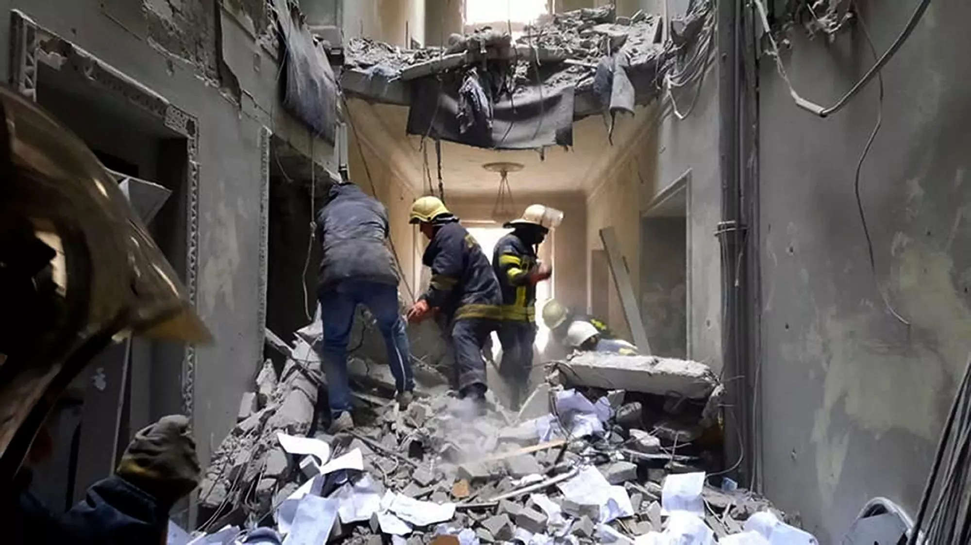 Emergency workers sort through rubble