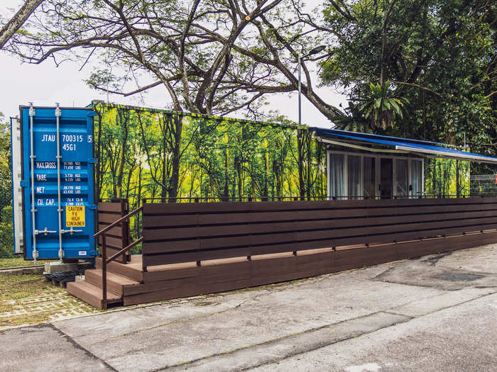 The units were decorated with a nature-theme print, with blue accents on the container doors and awning. A porch stretched alongside the front wall.