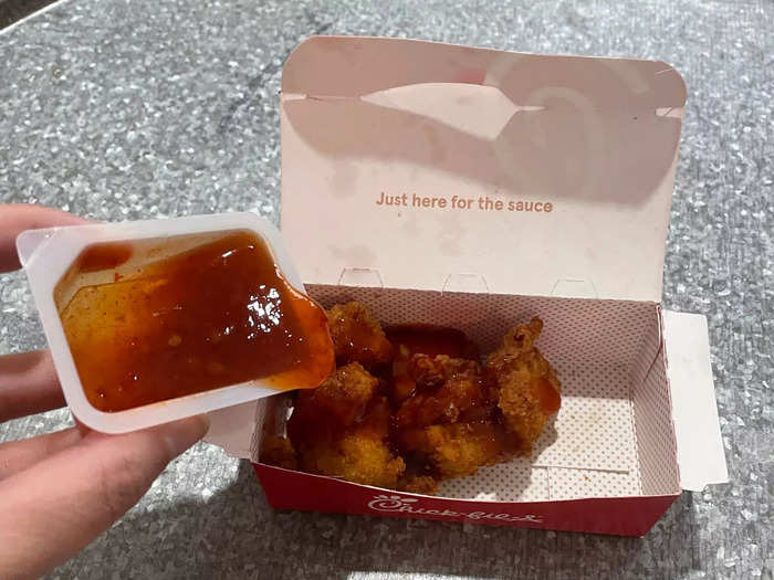 The first step is to drizzle the sauce over the nuggets either in the box or in a large bowl.