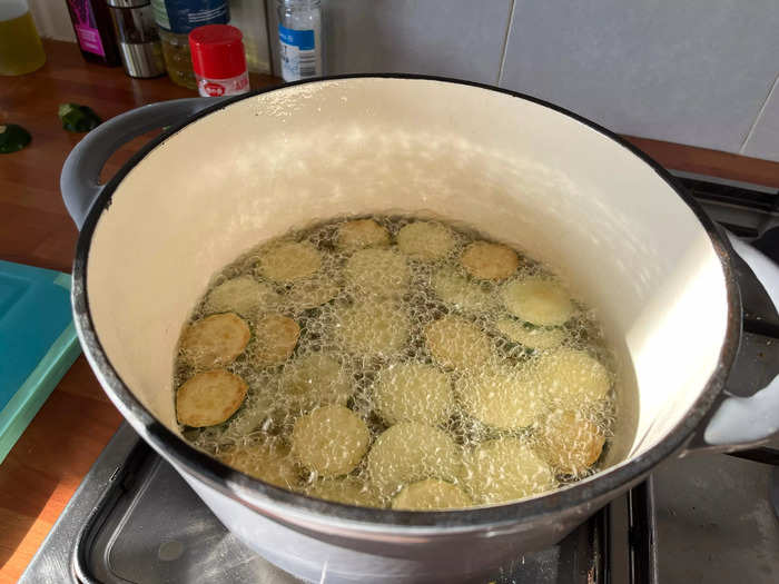To deep-fry the zucchini, place the zucchini discs into a pot of hot sunflower oil — you