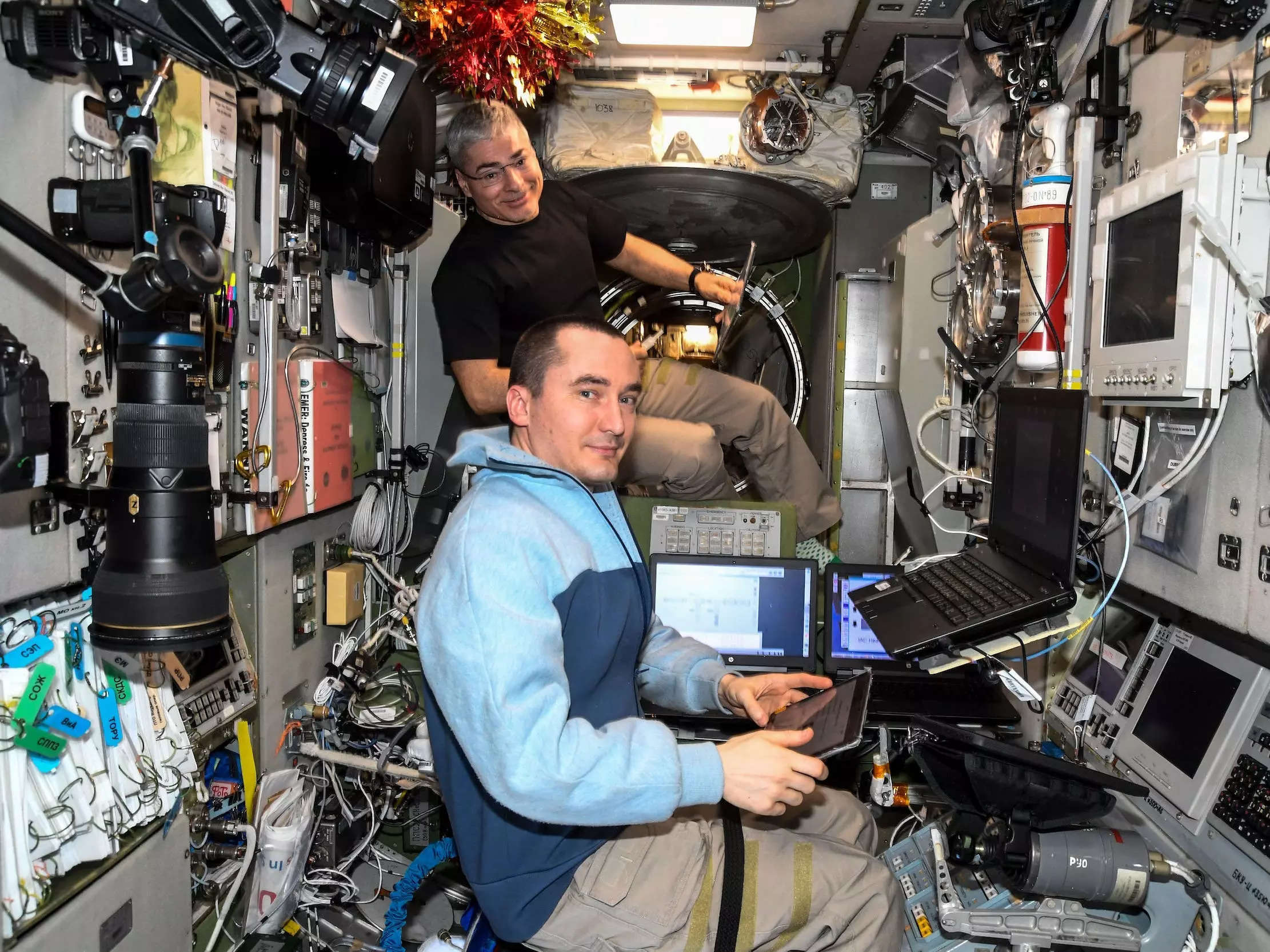 astronaut mark vande hei and cosmonaut pyotr dubrov use computer on space station