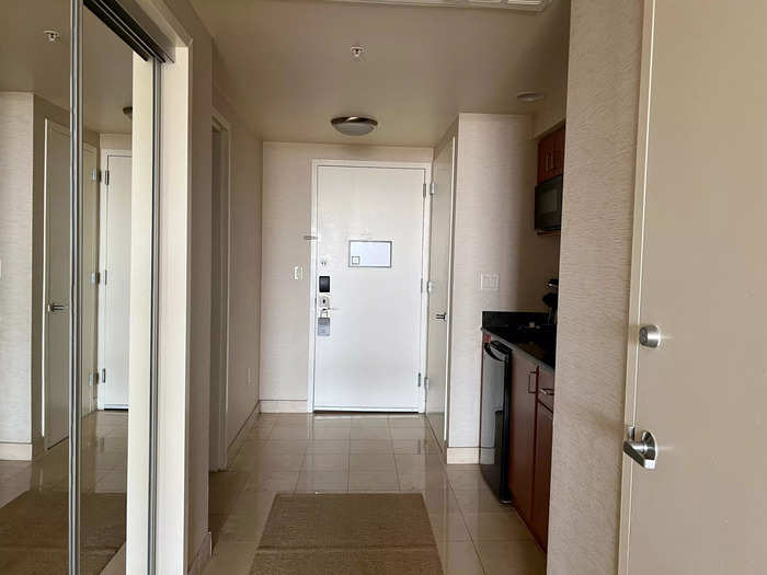 Matching beige walls and tile in the hallway between the kitchen and bathroom felt the same.