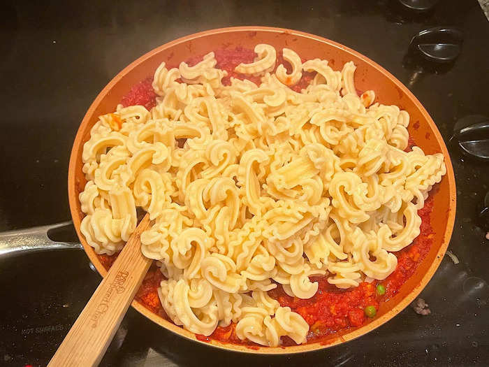 Then I drained my pasta and threw those thick and curvy noodles into the sauce.