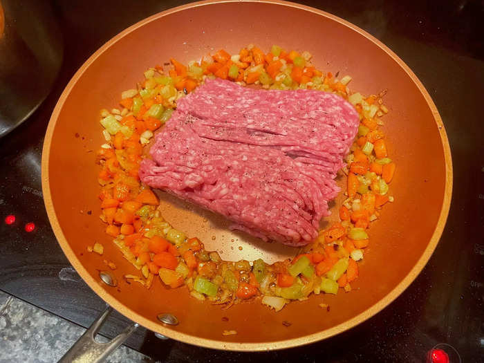 I moved my veggies to the edges of the pan, then added the ground pork.