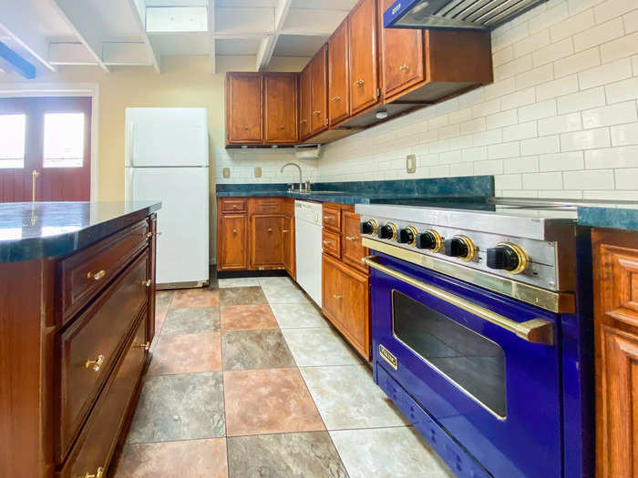 In the Baltimore apartment, the kitchen is much more spacious with unique design choices, like the tile flooring, the blue oven, and teal countertops.