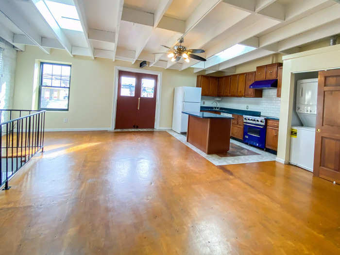 At the top of the stairs, in the Baltimore apartment, there is a spacious kitchen and living space with an open floor plan.