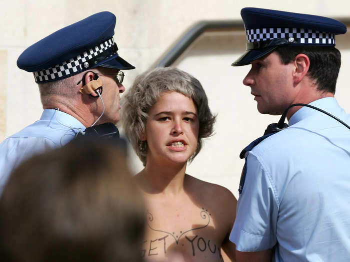 A topless protester who wrote "Get your colonial shame off my breasts" on her chest was arrested as Prince Charles toured New Zealand in 2005.