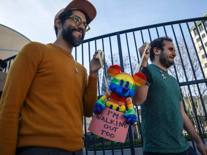 At the front of the line were two employees holding a rainbow-print Mickey Mouse toy.