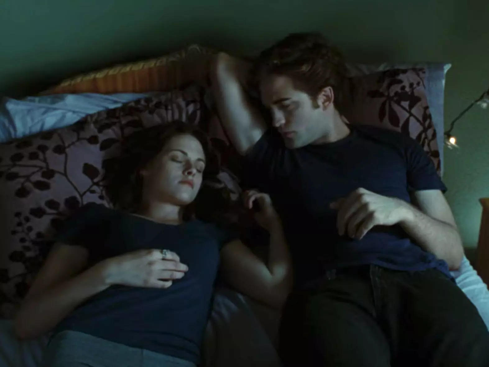 Edward (Robert Pattinson) watches Bella (Kristen Stewart) sleep in a scene from "Twilight."