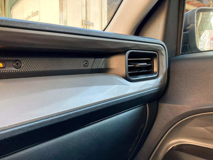 The upper part of the door panel features a molded diamond pattern that carries over to the dashboard and wraps around the air vents.