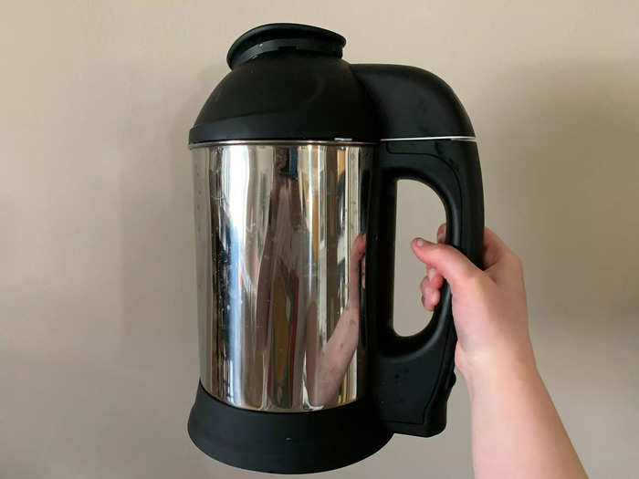 The plant milk maker is a large stainless steel pitcher with a black top and handle.