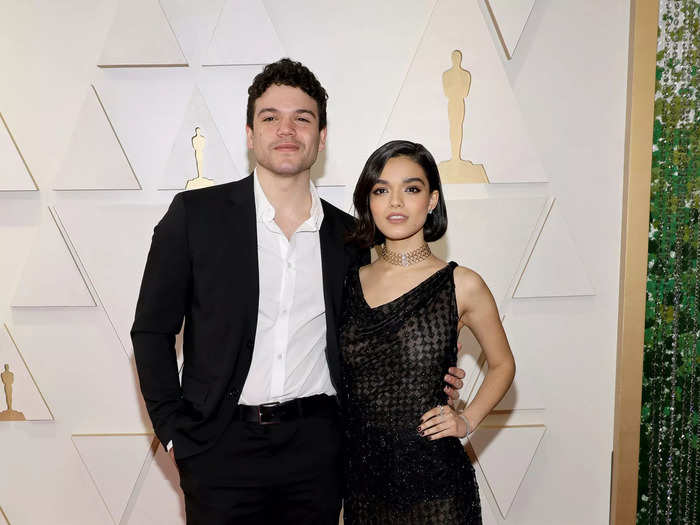 Josh Andrés Rivera and Rachel Zegler matched in black on the red carpet.