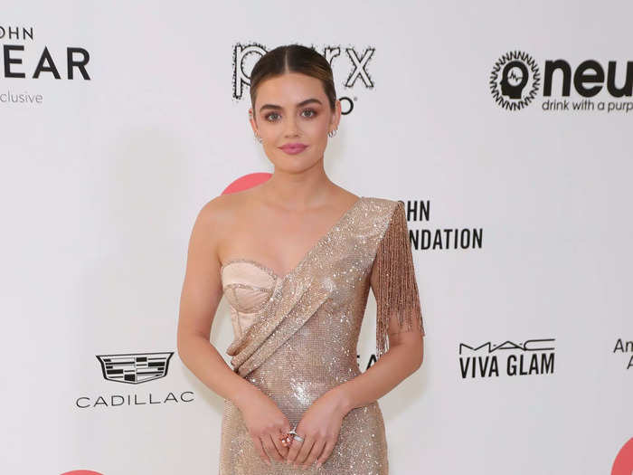 Lucy Hale dazzled in a tan, single-shoulder gown created by Dolce & Gabbana. It had a corset bodice covered with a sparkling overlay that featured a thigh-high slit.