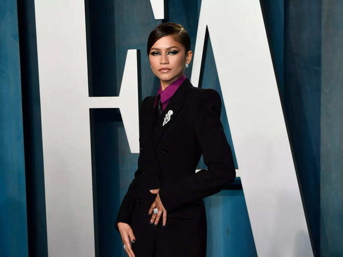 Zendaya suited up in a black a blazer and matching pants. She added a pop of color with a purple shirt, and rounded the look off with a tie.