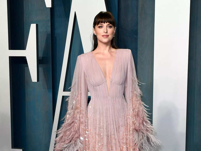 Dakota Johnson shimmered in pastel pink dress adorned with sparkly feathers.