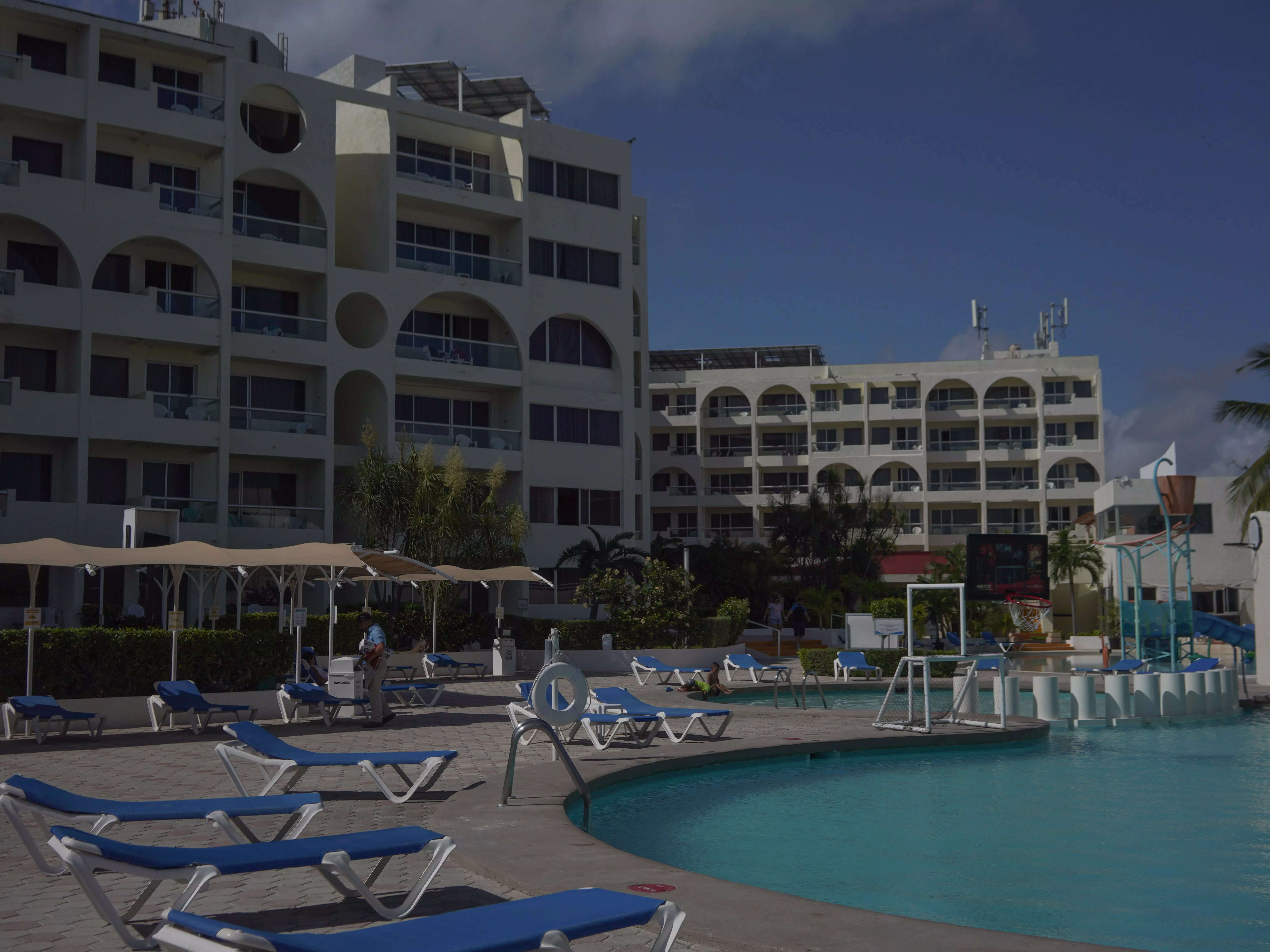 Aquamarina beach hotel; foldable chairs surround pool and resort in background
