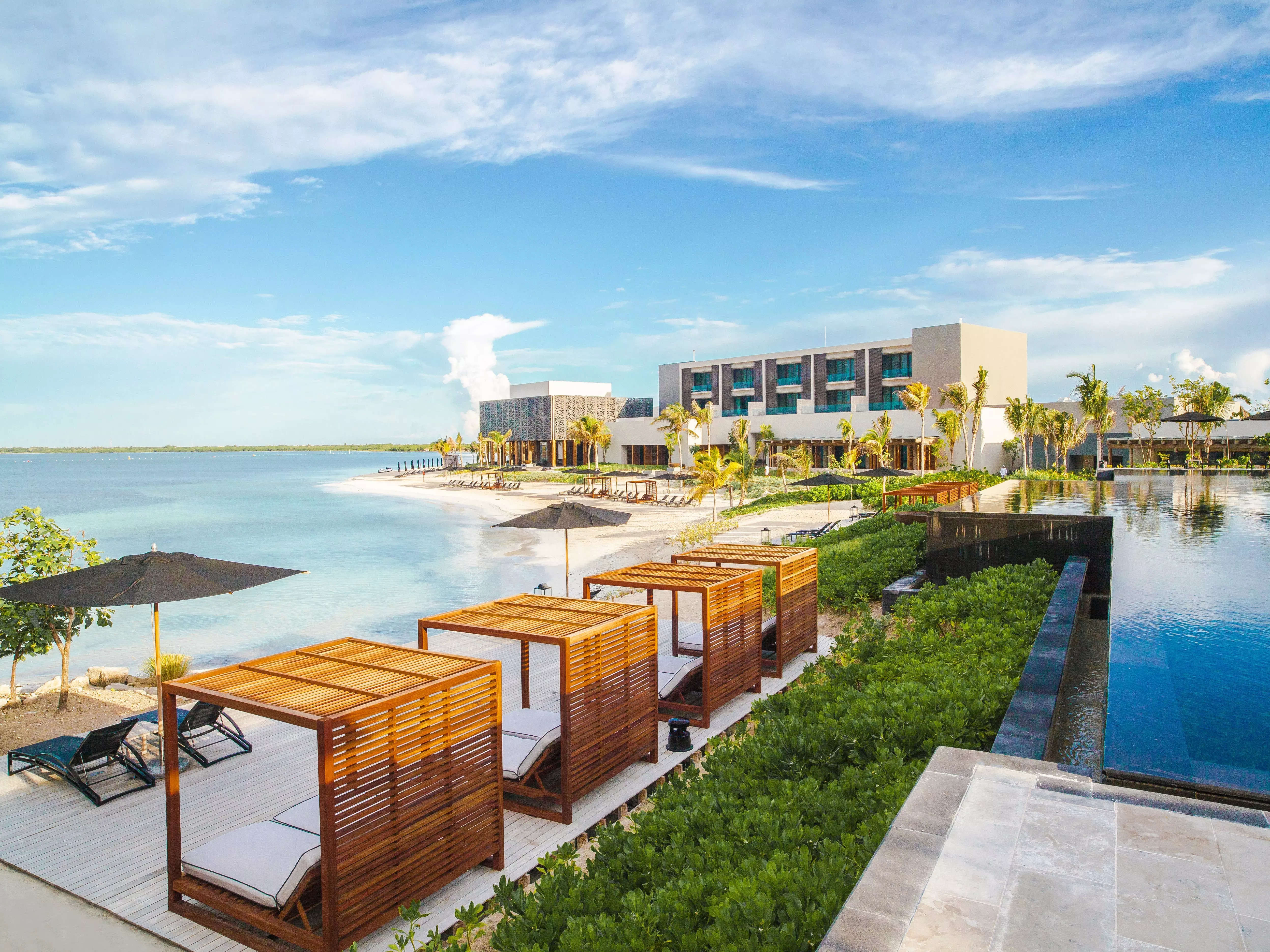 A beach hotel with cabanas facing the ocean.