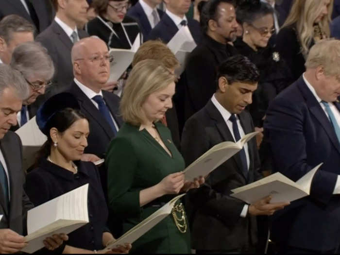 Attendees were photographed reading the Order of Service.