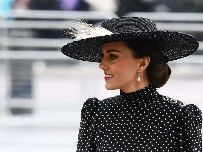 Guests dressed in muted tones. The Duchess of Cambridge paired a black-and-white, polka-dot dress with a black fascinator.