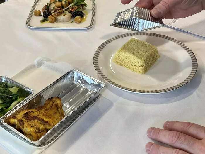 McNeil prepared the business class dishes to demonstrate how the flight attendants will plate the food onboard. For hot meals, the food is transferred from tins to a plate and then topped with sauces.
