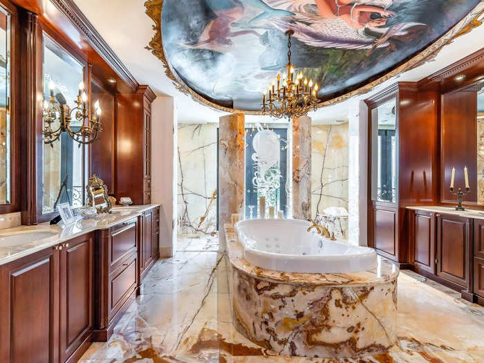 In the middle of the master bathroom, one of six full baths in the villa, sat a grand tub from which you could take in the view of a ceiling mural while soaking in the suds.