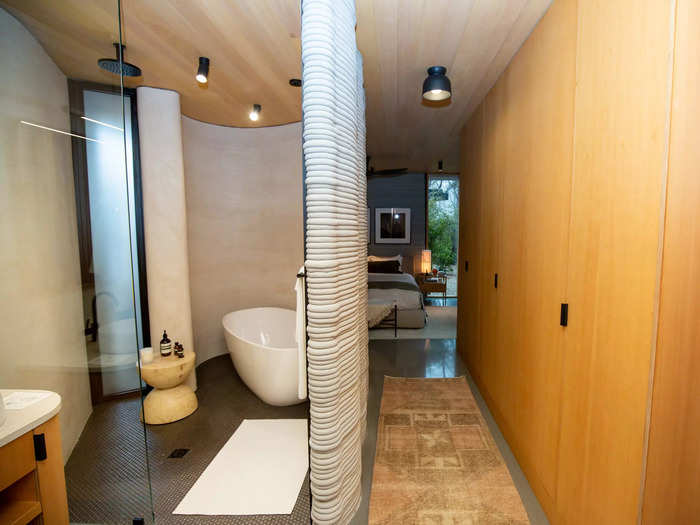 This bathing space also had a concave wall. But unlike the living room, the concrete layers were covered with a smooth grey finish.