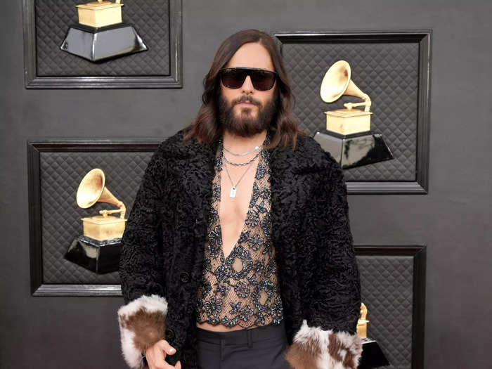 Jared Leto walked the red carpet in a plunging lace shirt and jacket with fur cuffs.