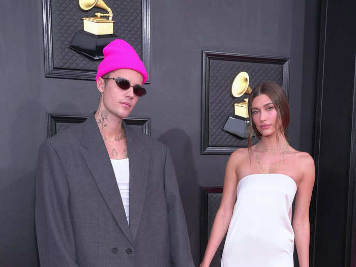 Justin Bieber showed up to the Grammys wearing an oversized grey suit, while Hailey Bieber opted for a simple strapless white silk dress.