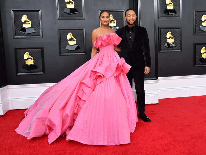 Chrissy Teigen wore a hot-pink gown with ruffles, while John Legend opted for a monochromatic black suit.